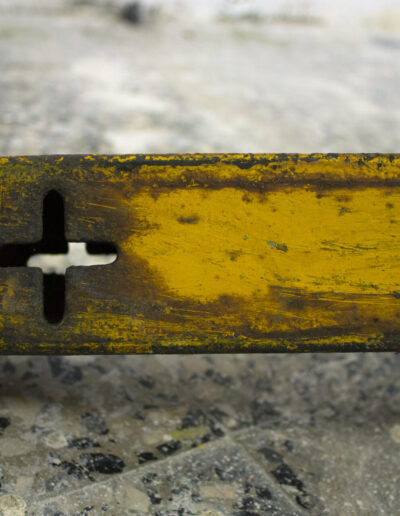 opera d'arte con palo di ferro giallo arrugginito